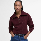 Woman wearing a burgundy Barbour knitted jumper with a white background